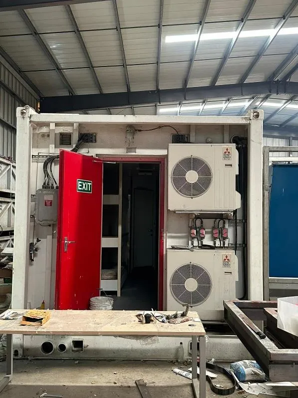 Entrada del contenedor con puerta de emergencia y aires acondicionados