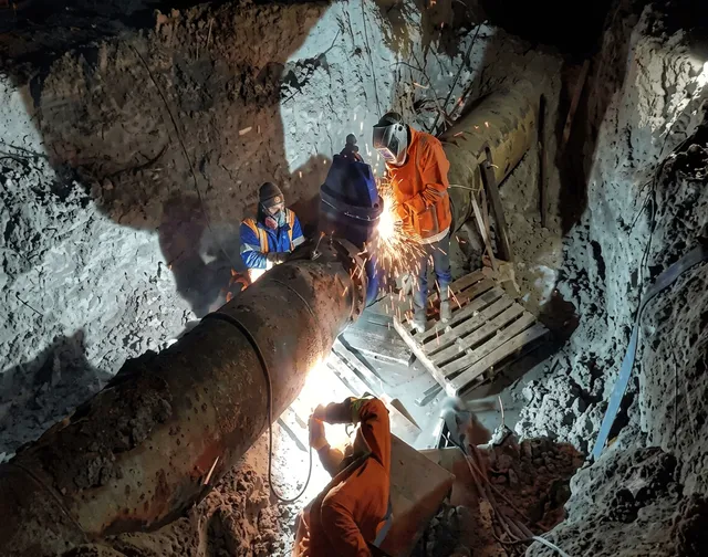 Soldadura de tubería dentro de zanja durante trabajos nocturnos